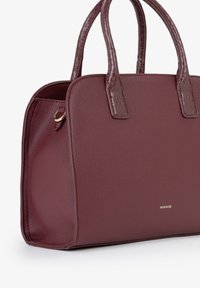 Borsa bordeaux con texture in pelle liscia, due manici corti e finiture in oro. Presenta un logo in rilievo discreto sul fronte.