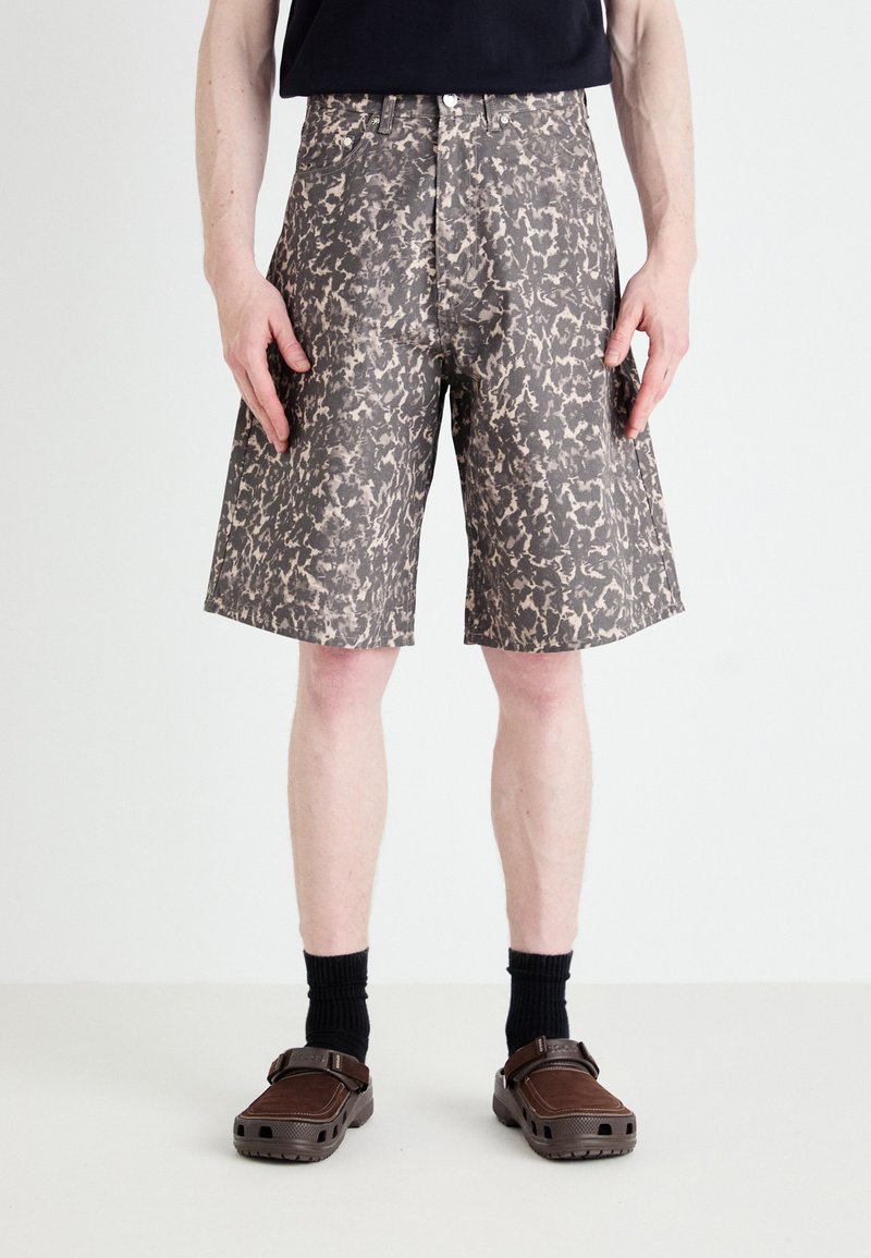 Shorts de estampado negro y beige, fabricados en una tela ligera, con un corte recto, bolsillos laterales y una cintura alta.