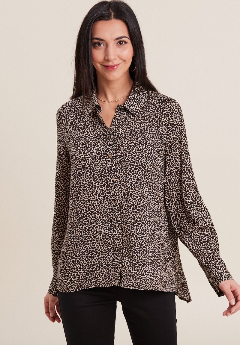 Chemise à boutons en imprimé léopard beige et noir, à manches longues avec poignet, légère texture, tissu doux et design à ourlet arrondi.