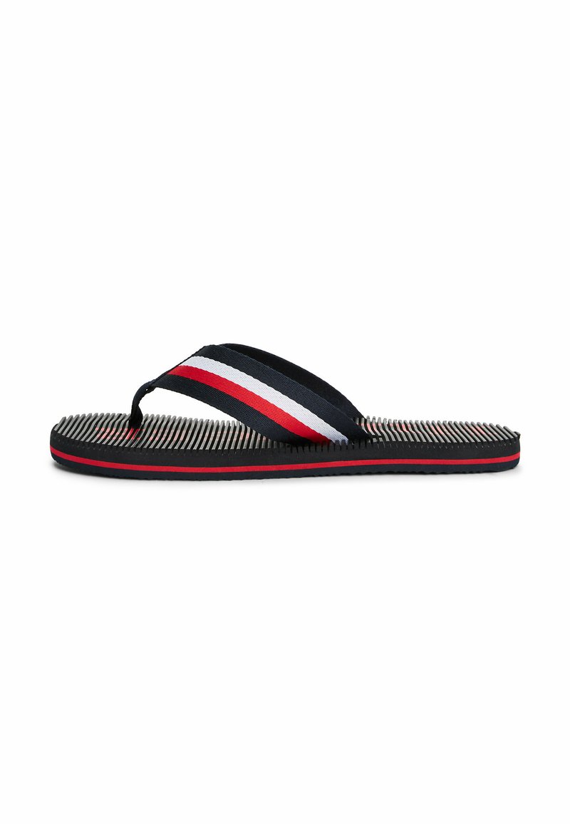 Flip-flop med sort gummisål, tekstureret fodseng og marineblå stropper med røde og hvide striber. Designet inkluderer en thong-stil.
