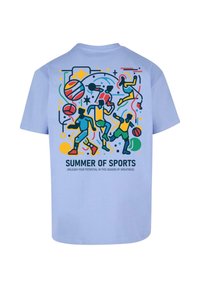 Světle modré bavlněné tričko s barevným sportovním motivem na zádech, které zobrazuje různé sportovce a nápis "LÉTO SPORTU."