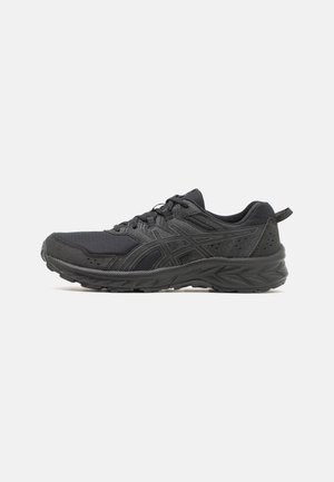Zapatillas deportivas negras con parte superior de malla, acentos texturizados, diseño de cordones y suela acolchada. Presentan una marca en el lateral y la parte trasera.