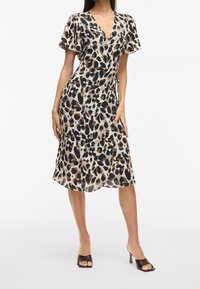 Vestido cruzado con diseño de estampado de leopardo, que presenta mangas cortas con vuelo, un escote en V profundo y una falda fluida, confeccionado en una tela ligera.