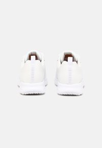 Baskets blanches en matériau synthétique lisse, avec un bout rond, des panneaux en maille texturée et une languette arrière. Semelles épaisses en caoutchouc blanc.