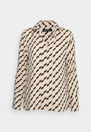Blouse crème à manches longues avec motif géométrique diagonal noir, beige et rose et col classique.