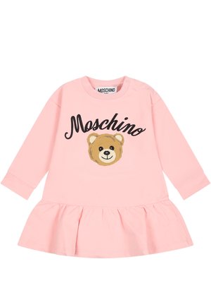Lyserød babykjole med lange ærmer og flæsekant, med teksten "Moschino" og et smilende bamseansigt på fronten.