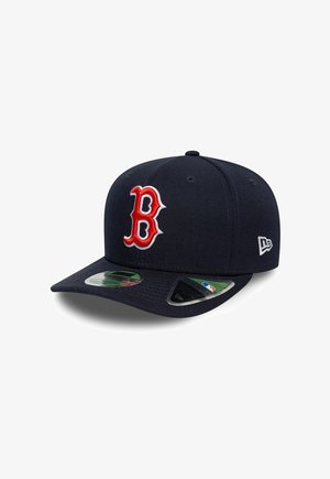 Marineblaue Baseballkappe mit rotem und weißem „B“-Logo vorne und weißem New Era-Logo an der Seite, mit Aufkleber-Etiketten am Schirm.