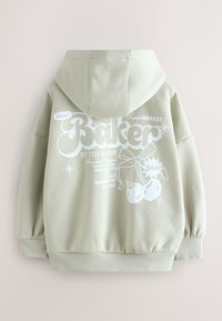 Világoszöld kapucnis pulóver nagy fehér grafikával a hátán, rajta a "Baker" felirat és díszítő elemek, mint cseresznye és csillagok.