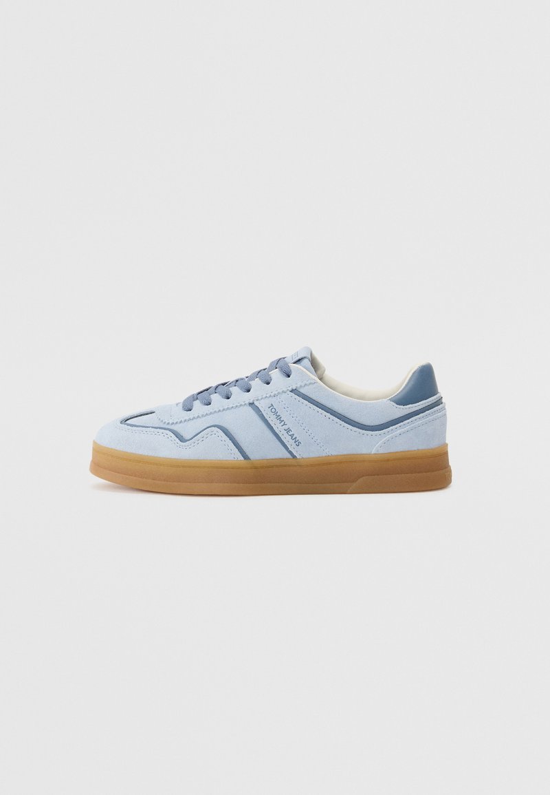 Zapatillas de ante azul claro con suela de goma, acentos azules contrastantes y costuras tonales. Los cordones y el logotipo en el lateral completan el diseño.