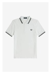 Witte poloshirt van katoen, met een zwarte gestreepte kraag en mouwafwerkingen, voorzien van een klein geborduurd logo op de linkerborst.