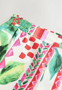 Material cu imprimeu floral, având frunze verzi, forme geometrice roz și accente roșii. Talie elastică și textură fină. Material ușor.