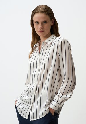 Witte blouse met marineblauwe verticale strepen, lange mouwen, knoopsluiting aan de voorzijde en gespreide kraag. Lichtjes losse pasvorm, gladde stof.