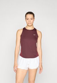 Camiseta deportiva sin mangas en color burdeos, hecha de un tejido transpirable, con cuello redondo, paneles laterales de malla y un pequeño logo blanco en el pecho.