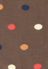 Brunt stof med en strikket tekstur, der har multikolorede polka-dots i rød, orange, marineblå, cremefarvet og tan, jævnt fordelt over overfladen.