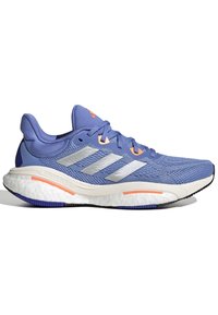 Light purple athletic shoes featuring a textured mesh upper, silver three stripes, orange accents, and a cushioned white midsole.