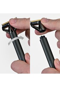 Musta tarkkuuspartahöylä, jossa irrotettava terä ja sileä mattakahva, osoittaa kiertoliikettä terän irrottamiseksi tai kiinnittämiseksi.