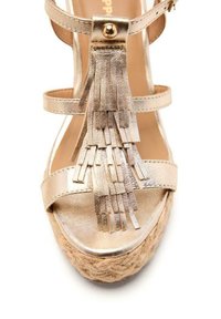 Sandale en métal doré avec semelle en jute tissée, dotée de plusieurs brides de cheville et d'un détail frangé décoratif à l'avant. Talon plat.