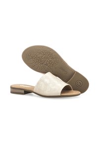 Beiga mockaimar skor med en bred öppen tå-design, en låg blockklack och ett blommotiv på den bruna gummisulan.