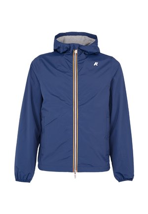 Giacca leggera con cappuccio blu, chiusura frontale con cerniera e polsini elastici, con un piccolo logo bianco sul petto superiore sinistro.