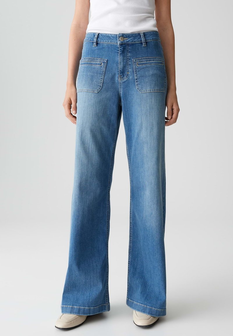 Weite blaue Jeans mit einem hellen Waschung, fünf Taschen, Gürtelschlaufen und einer klassischen Knopfverschluss. Glattes Denim-Material.