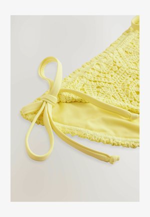 Geel gehaakte bikini-top met een gestructureerd patroon, vastgebonden bandjes en een gladde voering, met een geschulpte rand aan de onderkant.
