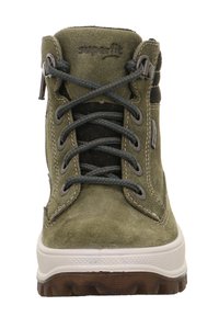 Groene suède enkellaars met grijze veters, rubberen zool, gevoerde kraag en versterkte lussen. Kenmerkt zich door een logo op de tong.