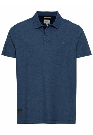 Sininen lyhythihainen poolopaita, jossa on teksturoidusta kankaasta valmistettu materiaali, kaksinappinen nappilista, pieni logo rinnassa ja kangasmerkki helman läheisyydessä.