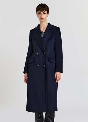 Lungo cappotto di lana blu navy con design doppiopetto, ampie alette, e tasche laterali, con texture liscia e bottoni lucidi.