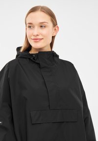 Black waterproof jacket with a hood, featuring a front pocket, high collar, and drawstring adjustments. Smooth texture, minimal design.