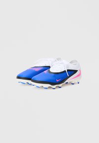 Μπλε συνθετικά ποδοσφαιρ ικά παπούτσια με λευκά κορδόνια, μαύρες λεπτομέρειες, υφή στην επάνω επιφάνεια, ροζ λογότυπο και πολλούς τακούνες σε λευκή σόλα για πρόσφυση.