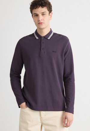 Violet ilgio rankovių polo marškiniai su smailiu apykakle, turintys pilkas juosteles, tris sagas ir mažą juodą logotipą ant krūtinės.