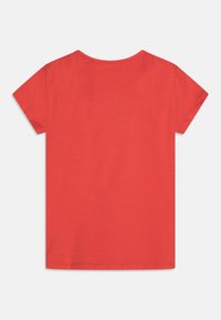 Punainen lyhythihainen t-paita, valmistettu puuvillasta. Ominaisuuksiin kuuluu pyöreä kaula-aukko ja sileä pinta. Selkäpuoli on yksivärinen ilman kuvioita tai koristeita.