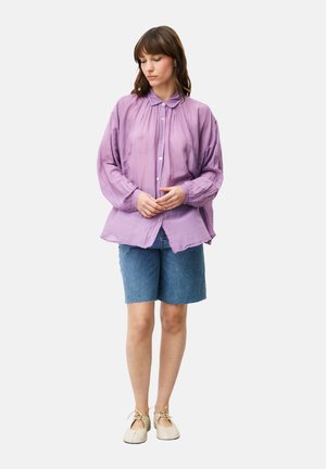 Lila, locker sitzendes Langarmhemd mit Button-Down-Kragen, kombiniert mit Jeansshorts und beigen Schuhen. Einfaches Design, weicher Stoff.