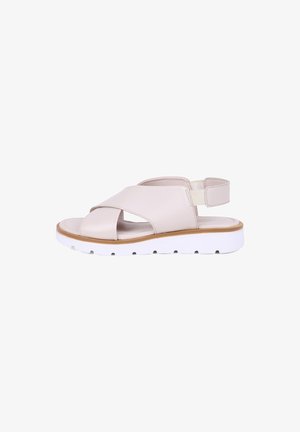 Beige leren sandaal met brede gekruiste bandjes, elastische enkelband, gevoerd voetbed en dikke witte geribbelde zool voor comfort en ondersteuning.