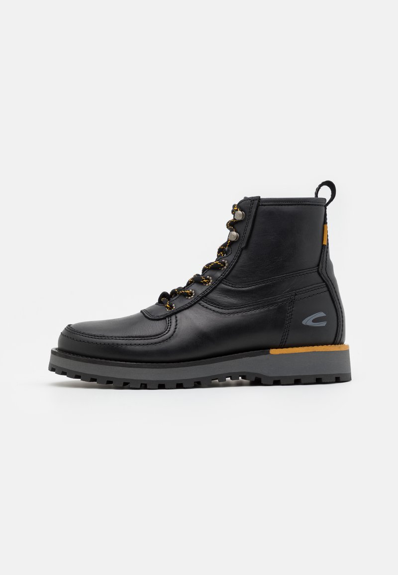 Black leather boot with a rounded toe, featuring metallic eyelets and orange accent on the heel. Textured rubber sole for grip.