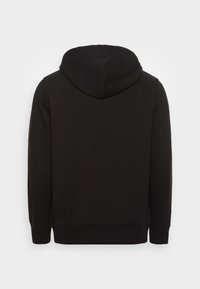 Sudadera negra de manga larga vista desde atrás, con capucha y puños y dobladillo acanalados sobre un fondo blanco.