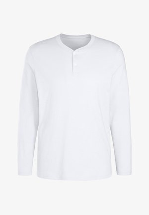 Maglietta henley bianca a maniche lunghe in cotone, con scollatura rotonda, patta con tre bottoni e texture liscia.