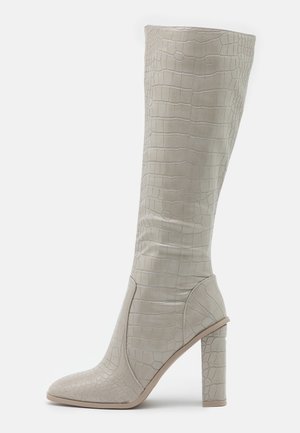 Knee-high, light gray boots with a textured crocodile pattern, pointed toe, and a sturdy block heel. Made of synthetic material.
