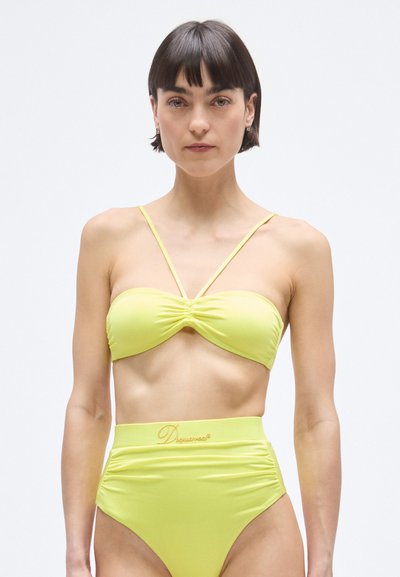 Ensemble bikini jaune composé d'un haut bandeau torsadé et d'un bas taille haute, fabriqué en tissu lisse avec un design minimaliste.