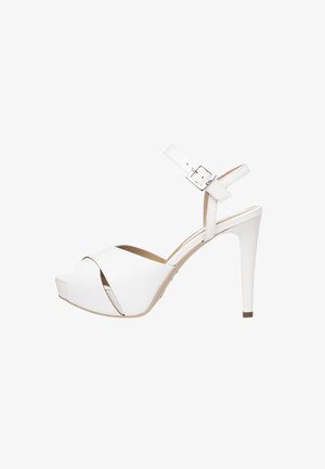 Sandalias de tacón alto blancas con un diseño de cruce en la parte delantera, tiras en el tobillo con detalle de hebilla cuadrada y suela de plataforma. Material sintético suave.