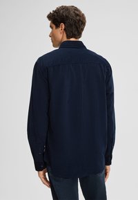 Marineblaues lang�ärmliges Hemd mit Button-Down-Kragen, aus einem glatten Material gefertigt, mit einem abgerundeten Saum und Manschetten.