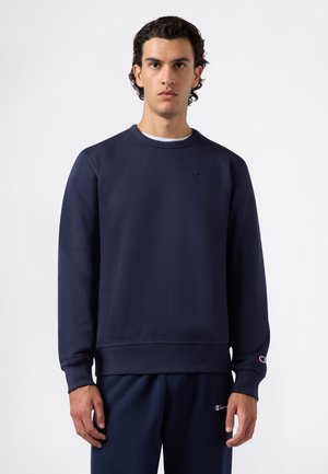 Marineblaues Sweatshirt aus weichem Stoff, mit Rundhalsausschnitt, gerippten Bündchen und kleinem Logo auf der Brust. Kombiniert mit passenden Hosen.
