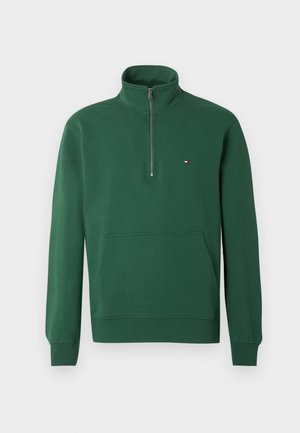 Ciemnozielona bluza z suwakiem do ćwiartki, z wysokim kołnierzem, przednią kieszenią kangurzą, ściągaczami i małym czerwono-biało-niebieskim logo na piersi.