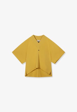 Yellow short-sleeve V-neck blouse with a single button, asymmetrical hem, and side slits on a white background.