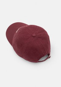 Burgundy színű baseball sapka pamut anyagból, ívelt napellenzővel, hátul állítható pánttal és varrott részletekkel a fejtetőn.