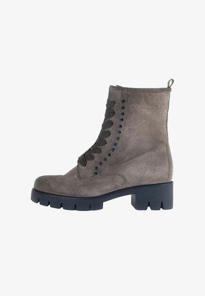 Bottine en daim gris avec un talon bloc, dotée d'un bout arrondi, de lacets latéraux, de œillets en métal et d'une languette à l'arrière.
