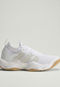 Λευκό αθλητικό sneaker με πλέγμα επάνω μέρος, μπεζ στοιχεία, κλείσιμο με κορδόνια και σόλα από καουτσούκ σε φωτεινό φόντο, πλευρική όψη.