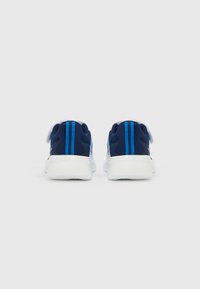 Adidași sport bleumarin cu tălpi albe, având un material texturat, două dungi verticale albastre și o închidere cu bandă sigură.