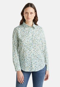Camicia a bottoni floreale in azzurro chiaro e verde. Presenta un colletto, maniche lunghe e un tessuto morbido con un delicato motivo a foglia.