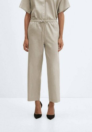 Pantalon beige ample avec taille élastique et cordon de serrage. Fabriqué en tissu lisse et léger. Devant plat, jambes droites.